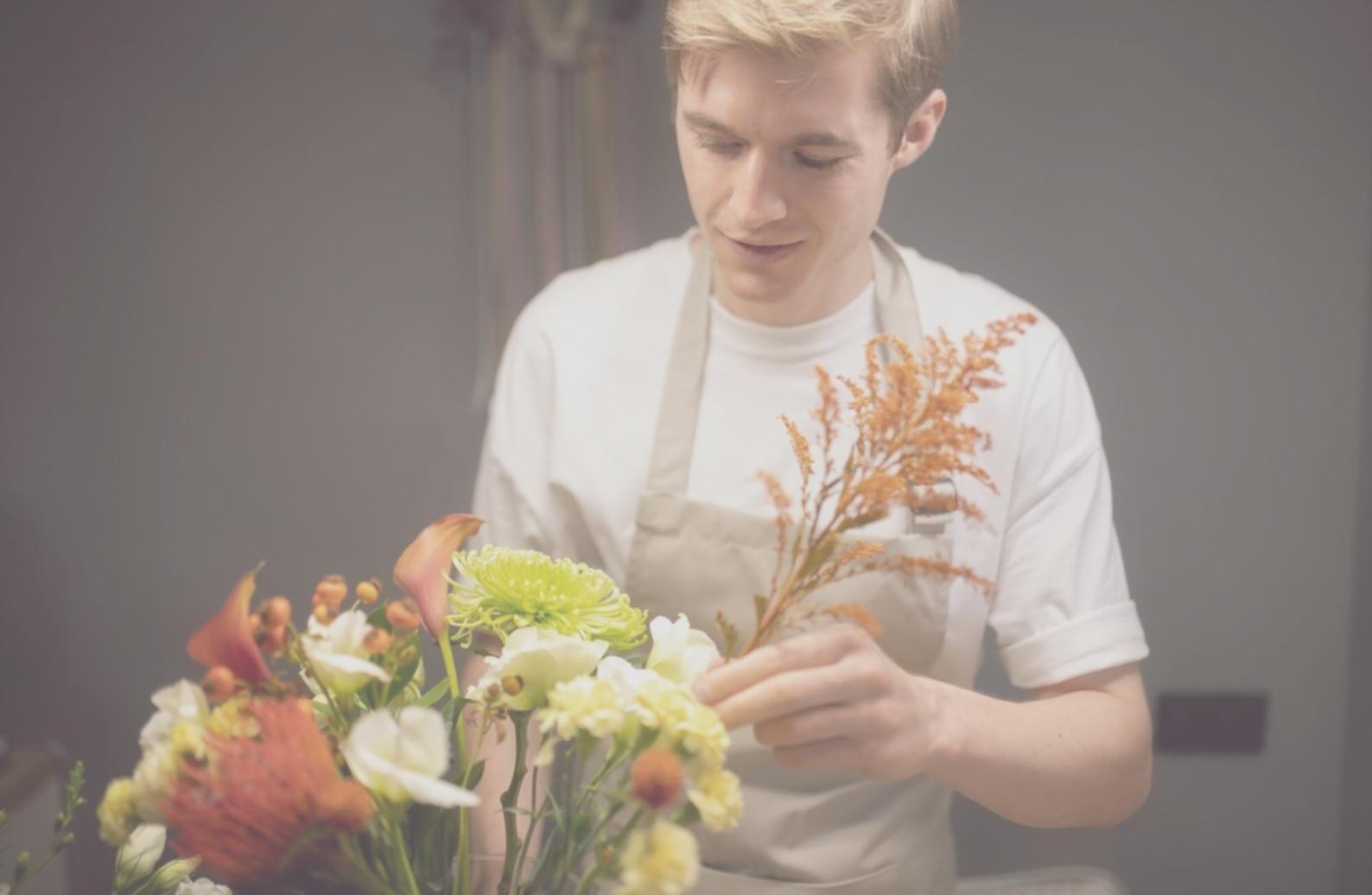 Student working on floral arrangement during live masterclass